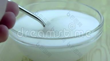男人用勺子吃透明杯里的酸奶，准备插入健康草莓，健康水果的概念食品